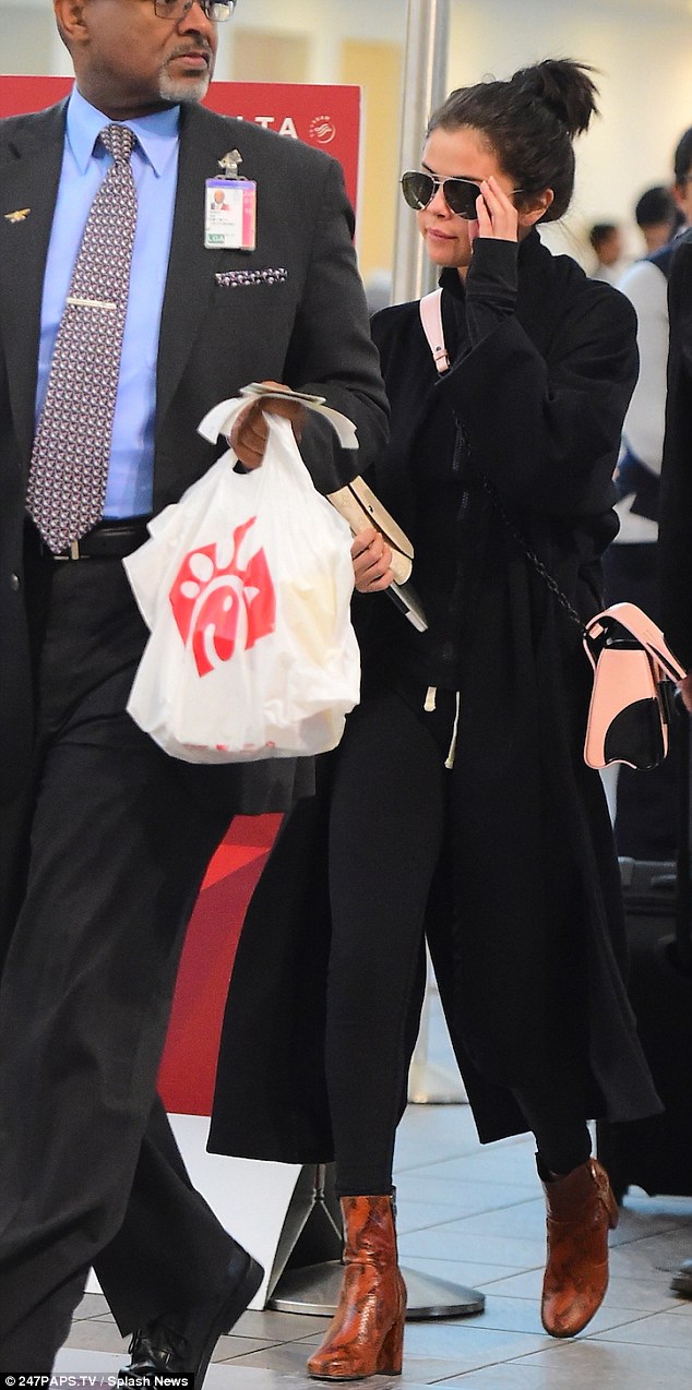Selena gomez brown snkeskin boots black coat pink bag photo 247PAPS TV Splash News