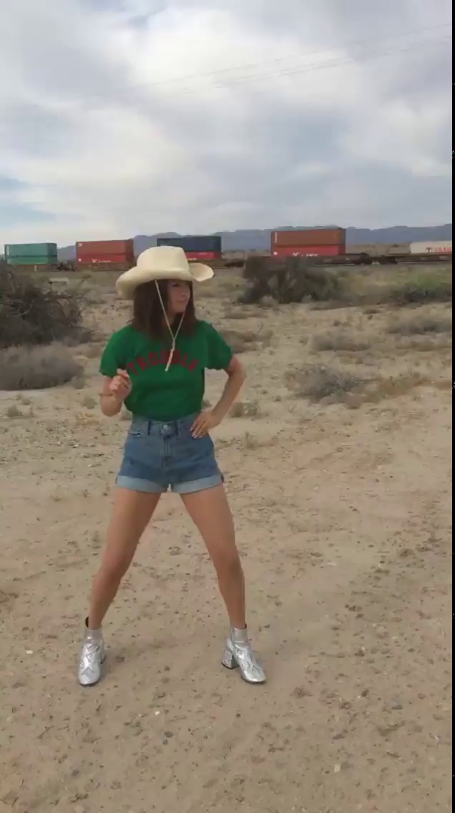 Selena Gomez Trouble t-shirt denim shorts silver cowboy boots photo anna collins