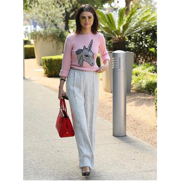 Selena Gomez pink unicorn sweater grey trousers black shoes red bag yellow sunglasses August Selena Gomez Style 2017