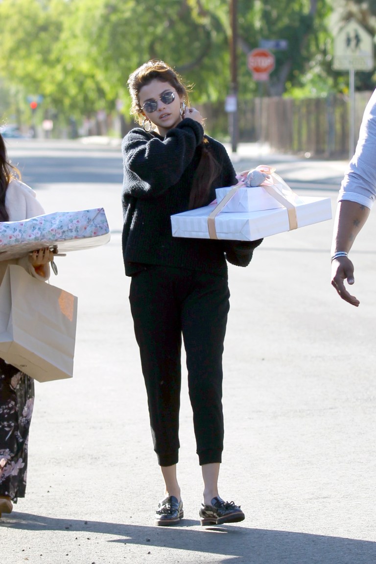 Selena Gomez style black loafers black sweater black sweatpants silver hoop earrings February 2018