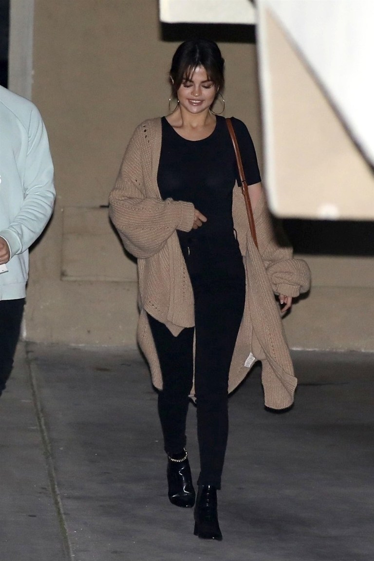 Selena Gomez black t-shirt black jeans black ankle boots beige oversized cardigan March 2018