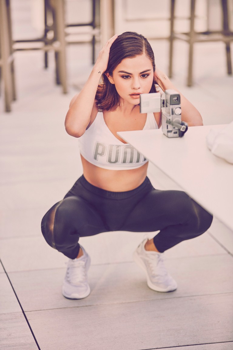 Selena Gomez style clothes outfit white Puma cropped top black leggings white grey trainers