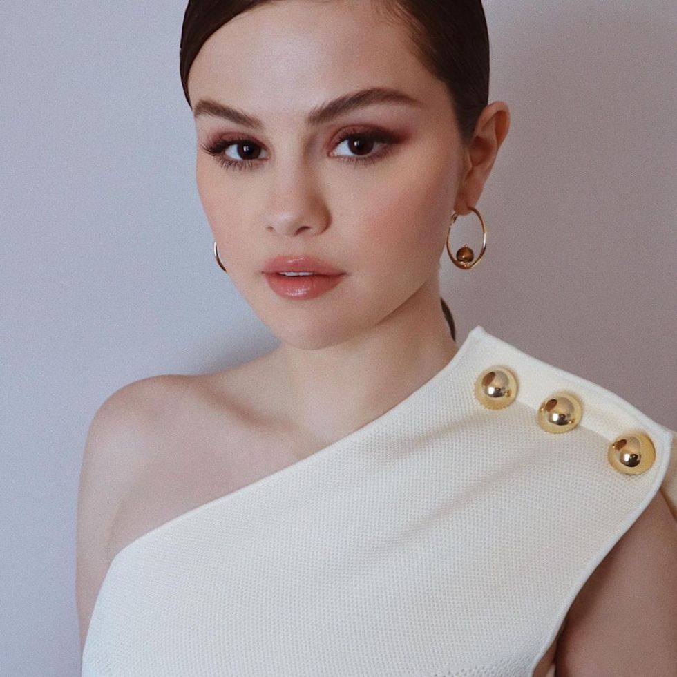 where to get Selena Gomez white asymmetric dress gold buttons gold hoop earrings 8 February 2021 Photo Kate Young