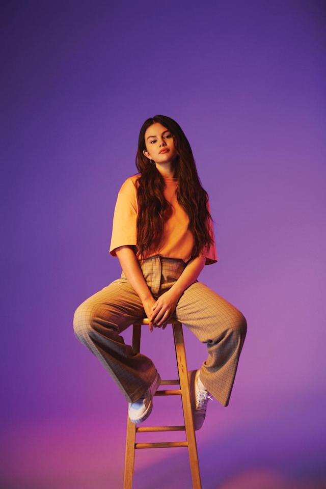 where to get Selena Gomez WWD beauty orange top khaki trousers white trainers gold hoops Photo Maddie Cordoba WWD